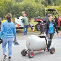 Katie Bujold voit aux bolides alors que d’autres les remontent pour la prochaine course – Photo : Michel Fortier