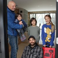 Zofia, Milann, Mareck avec papa et grand-papa, heureux de participer à la guignolée, une belle leçon de vie! – Photo : Yves Briand